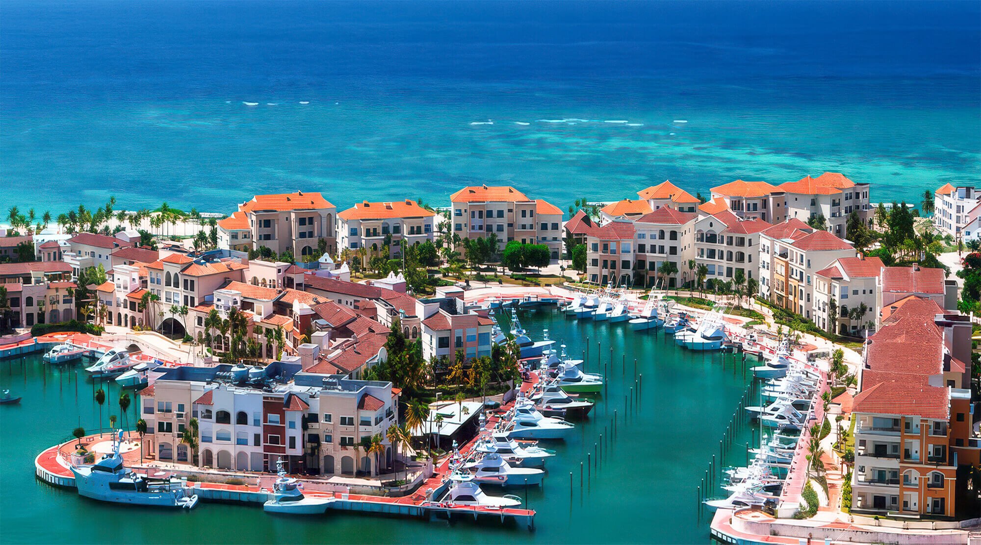 Aerial photograph of Marina Cap Cana, not of Makai: sport-fishing boats and yachts moored along its inlet, about 4.4 miles by road from the development.
